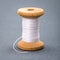 Vintage wooden spool of white sewing thread