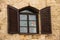 Vintage wooden window with shuttered in stone wall