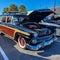 A vintage woody station wagon automobile in a free to the public Cars and Coffee car show