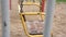 Vintage yellow metal swing sways in wind close side view