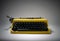 Vintage yellow typewriter in evocative spotlight