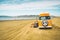 Vintage yellow van on the beach with cloudy sky on background, retro color effect. Oceano Dunes, California Central Coast