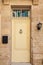 Vintage yellow wooden door in stone wall. Malta