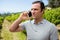 Vintner talking on mobile phone in vineyard