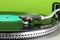 Vinyl record player on green background, close-up