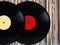 Vinyl records in front of pile of many close standing vinyl disks in old color covers over black background