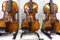The viola and two classical violins stand on stands