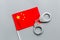 Violation of law, law-breaking concept. Metal handcuffs on Chinese flag on grey background top view