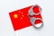 Violation of law, law-breaking concept. Metal handcuffs on Chinese flag on white background top view