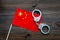 Violation of law, law-breaking concept. Metal handcuffs on Chinese flag on wooden background top view