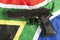Violent crime concept with a handgun and South African flag