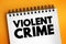Violent crime - in which an offender or perpetrator uses or threatens to use harmful force upon a victim, text concept on notepad