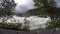 Violent rapid river waterfall during flood in late summer with dense forest slow motion