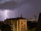 Violent summer thunderstorm with enormous lightning over the Wienerberg City in Vienna with construction cranes on the right side