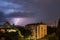 Violent summer thunderstorm with enormous lightning over the Wienerberg City in Vienna with construction cranes on the right side