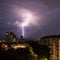 Violent summer thunderstorm with enormous lightning over the Wienerberg City in Vienna with construction cranes on the right side