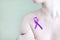 Violet awareness ribbon on the torso of a young girl. Copy space - concept of domestic domestic violence, symbol, danger