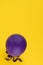 Violet balloon on a yellow background. Copy space. Party decoration.