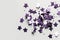 Violet confetti in the form of stars isolated on white. Illustration AI Generative