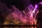 Violet fireworks on dark sky with trees and Vltava river