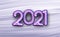 Violet foil balloon 2021 sign on brush strokes background