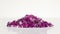 Violet jewel stones heap turning over white background
