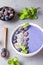 Violet magic smoothie bowl topped with blueberries, blackberries, coconut flakes and seeds.