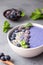 Violet magic smoothie bowl topped with blueberries, blackberries, coconut flakes and seeds.