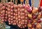 Violet onion hanging in a row for sale in the market