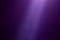 Violet ray of light illuminates a dark purple finely textured background