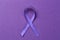 Violet ribbon on color background. Family violence, Alzheimer disease and pancreas cancer