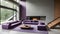 Violet-tufted sofa in a large, lavish room with a staircase and fireplace