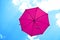 Violet umbrella flying on blue sky