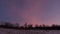 Violet winter skies after sunset above field and line of trees under Low Tatras mountains