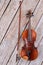 Violin and fiddle stick on wooden background.