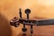 Violin instrument handle with strings and tuning pegs under warm light