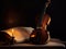 A violin sitting on top of a table next to a candle. Generative AI image.