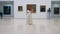 A violinist performs in a museum room alone, standing in a center.