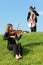 Violinist and violoncellist play against sky