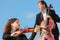 Violinist and violoncellist play against sky