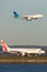 Virgin Australia Embraer regional jet ERJ-190 at Sydney Airport with a Garuda Airways Airbus A330 landing behind.