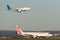 Virgin Australia Embraer regional jet ERJ-190 at Sydney Airport with a Garuda Airways Airbus A330 landing behind.