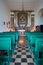 Virgin of the Snow ancient church interior with green pews in Prato Nevoso, Italy