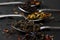 Virious kinds of tea in tea spoons on black table close-up, Assortment of teas. Black , green and fruit tea, dry tea leaves