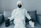 A virologist in viral protective suit with a medical mask laid hands in gloves on black and white skulls.  from the epidem