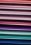 Virtical stacks of colored paper in various shades of pink, red and purple, turquoise and blue