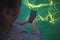 virtual classroom. Small child looking at cell phone, isolated on green and yellow graphs studio background