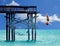 A virtual diver takes a risky turn diving off the end of a beach pier as a flock of pelicans fly by