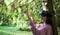 Virtual forest. A young woman among the trees, wearing virtual reality glasses, touches the boles and branches.