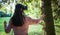 Virtual forest. A young woman among the trees, wearing virtual reality glasses, touches the boles and branches.